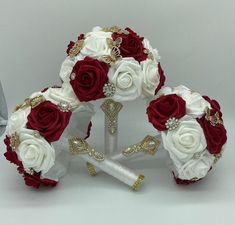 the bridal bouquets are arranged in white and red roses, with gold accents