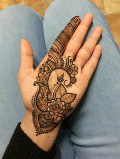 a woman's hand with henna tattoos on it