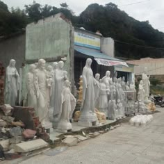 a bunch of statues that are on the side of a road