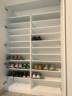 a white closet with several pairs of shoes on the bottom shelf and two rows of shelves below