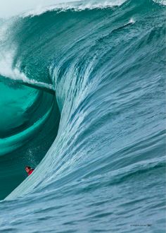 a man riding a wave on top of a surfboard in the ocean next to another person