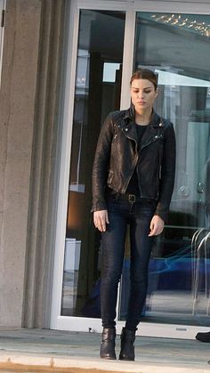 a woman is standing in front of a building