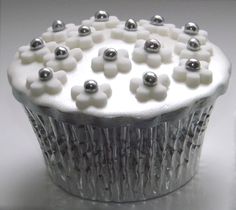 a cupcake with white frosting and silver decorations