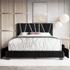 a bed with white sheets and black headboard in a room that has wood paneling on the walls