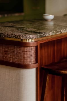 a counter top with a bowl on it and two stools in front of it