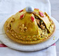 there is a pie that has been cut in half on the white plate with red and yellow decorations