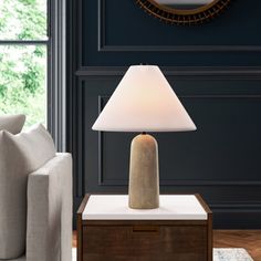 a living room scene with focus on the table lamp and sofa in the foreground