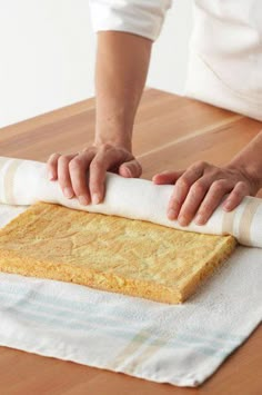 a person rolling out some bread on top of a table