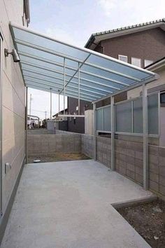 an enclosed patio with glass walls and sliding doors on the side of a building in front of a house