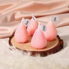 four pink soap cones sitting on top of a wooden slice