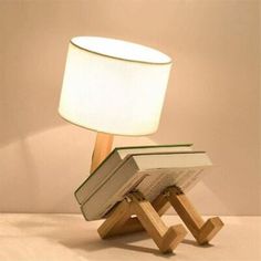 a lamp that is sitting on top of a wooden stand with books in front of it