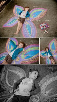 a little boy laying on the ground next to a chalk drawing butterfly with his wings spread out