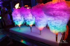 colorful cotton candy lollipops sitting on top of a white tray at a party