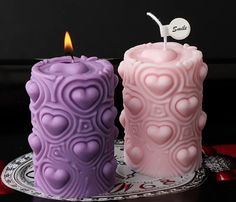 two candles sitting side by side on a plate