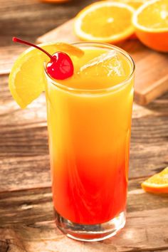 an orange drink garnished with a cherry