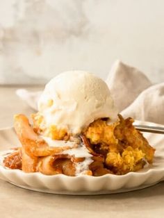 a close up of a plate of food on a table with a fork and ice cream