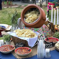 a table topped with lots of food next to a pot filled with pasta and sauces