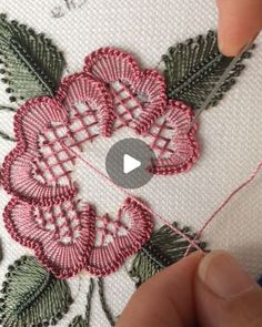 someone is stitching flowers on a piece of fabric