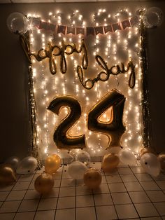 balloons and streamers are on the floor in front of a happy birthday sign