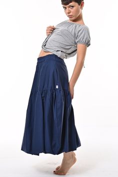 Tale: Make waves with this contemporary take on a 1850's puffball silhouette. Wear high in the waist or low as a hipster. The deep pockets are a great asset and the elasticated waist allows for expansion and comfort. Our model is 5ft 4" and wears an S with our Posey Top. Please see our size guide. 100% Cotton Skirt, 100% Polyester Lining Made in Britain 100% Woven Cotton Skirt, 100% Polyester Lining Wash at 30* Warm Tumble Dry Warm Iron Do Not Bleach Do Not Dry Clean Tiered Skirt With Pleated Waist And Voluminous Fit, Casual Voluminous Skirt With Gathered Waist, Blue Skirted Bottoms With Pleated Waist, Summer Navy Skirt With Pockets, Fitted Full Skirt With Gathered Waist, Daywear Bottoms With Gathered Waist And Tiered Skirt, Solid Color Tiered Skirt With Pleated Waist, Daywear Tiered Skirt With Gathered Waist, Cotton Skirt With Gathered Waist