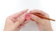 two hands are crocheting the end of a piece of yarn