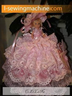 the doll is wearing a pink dress and hat with lace on it's skirt