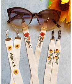 three sunflowers and sunglasses with the words good luck written on them next to two pairs of eyeglasses