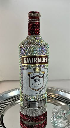 a bottle of smirnobff vodka on a tray with some crystal stones around it