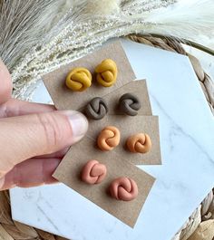 a person is pointing at some fake doughnuts on a paper towel next to a dried plant