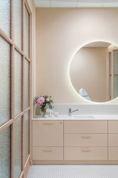 a bathroom with a round mirror above the sink