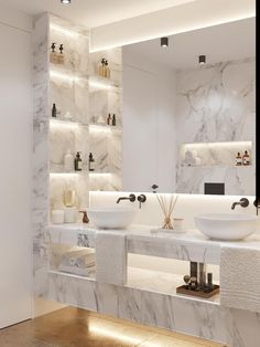 a bathroom with marble counter tops and two sinks in front of a large white wall