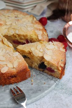 a piece of cake on a plate with a fork next to it and some berries