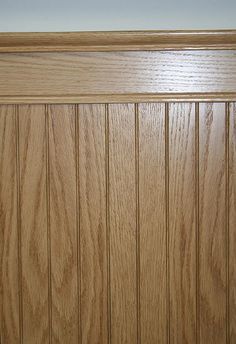 wood paneling on the side of a door with white walls in the back ground