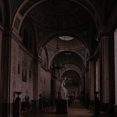 an empty hall with statues and paintings on the walls, in dark lighting at night