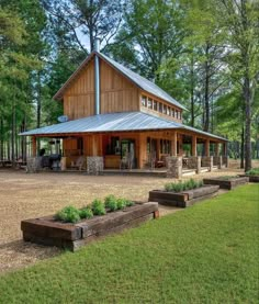 a large wooden building sitting on top of a lush green field next to trees and grass