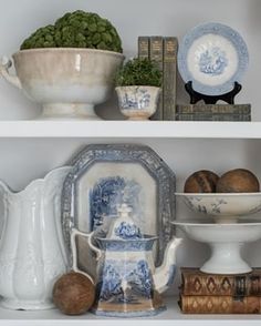 white shelves with blue and white china, books, and vases on top of them