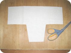 a wooden table with scissors and paper on it