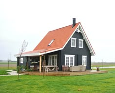 a small black house with a red roof