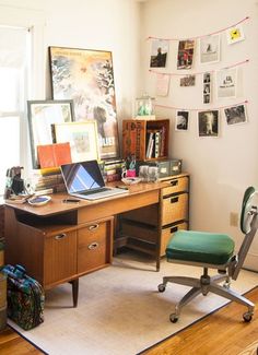 a room with several suitcases, a desk and a chair in it that is next to a window