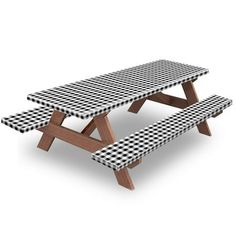 a picnic table with black and white checkered cloth on the top, sitting in front of a white background