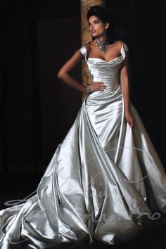 a woman in a white wedding dress posing for a photo with her hands on her hips