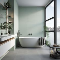 a bathtub sitting next to a large window in a bathroom near a body of water