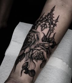 a black and white flower tattoo on the arm