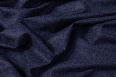 an image of a blue cloth textured with dark grey fabric and white stitching