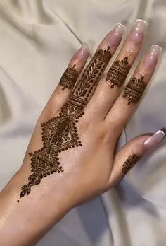 a woman's hand with henna tattoos on it