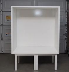 a white shelf sitting on top of a wooden table in a room filled with boxes