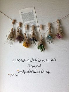 there are many flowers hanging on the clothes line with some words in english and arabic