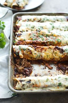 an enchilada casserole with meat and cheese in a baking pan