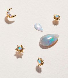 three opal studs and two moon shaped earrings