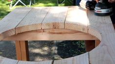 a person sanding wood on top of a wooden table